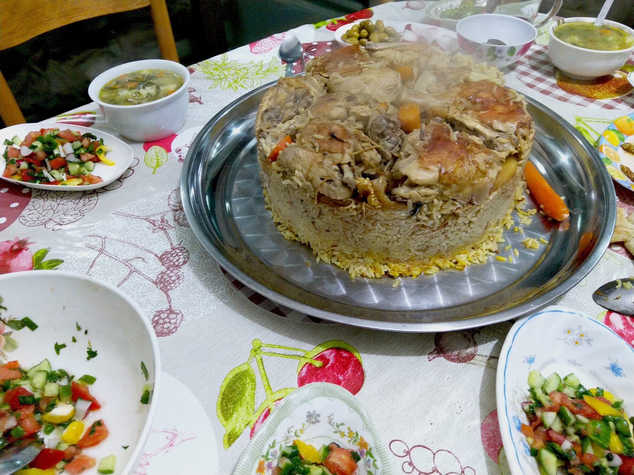 Maqluba on a family table with bowls of salad
